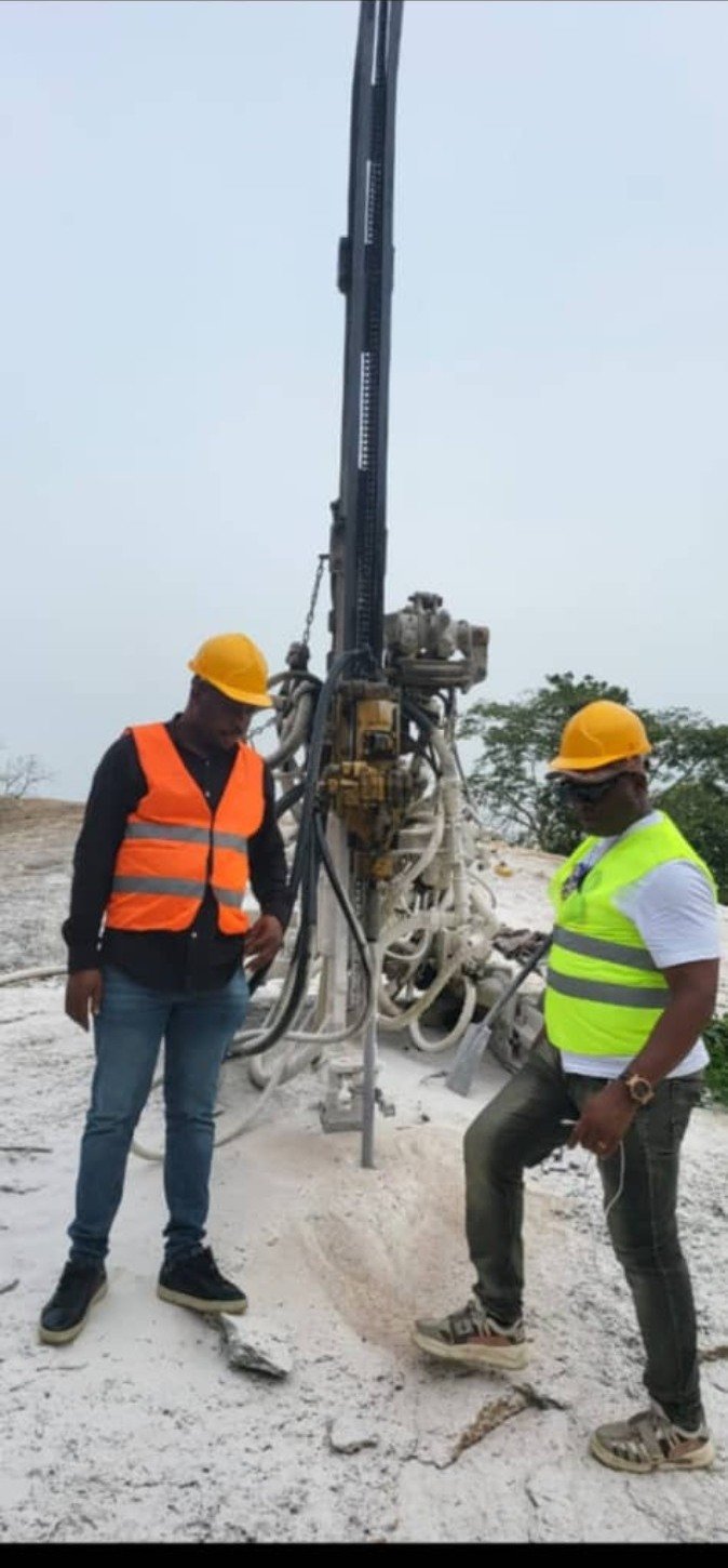 Ferros field personnel beside drilling equipment at Apata Oloyede